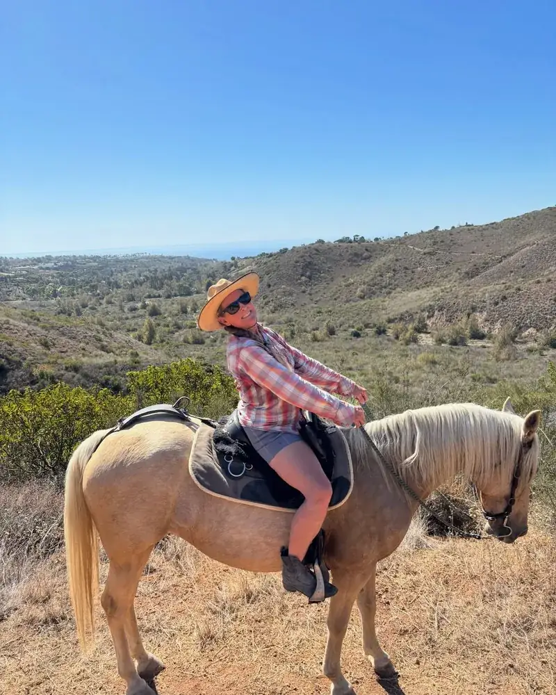 A rider in a hat on a palomino in the canyon