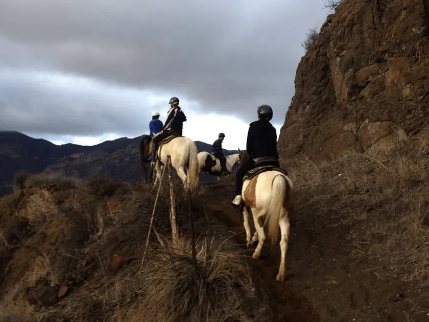 Riders on the rocks under a dramatic sky